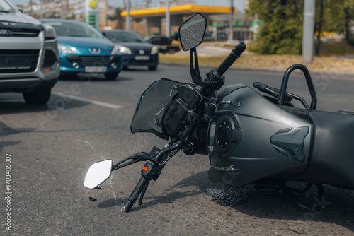 The motorcycle lies on the sidewalk after a ride. Serious accident. Accident, close-up. Lost control and fell. Driving hazards. Collisions with another vehicle.