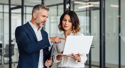 Smiling young businesswoman effectively boosting business productivity while working on her laptop in a contemporary office, ample copy space available
