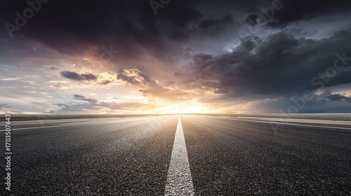 The road stretches straight to the distant horizon, with the sky in the background providing ample whitespace for text or design elements, showcasing a spacious and expansive roadside scene.