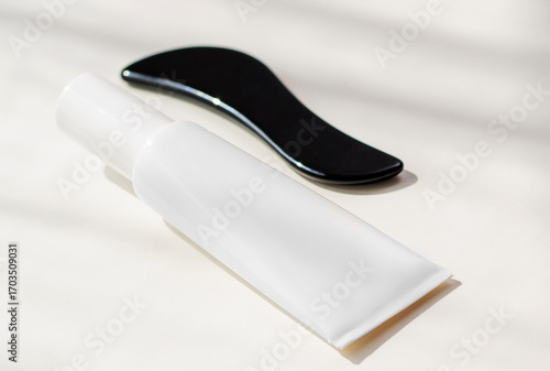 Gua sha tool and skincare cream displayed in a serene bathroom setting for wellness and beauty rituals