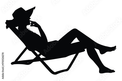 Silhouette shows a relaxing woman wearing a hat and chilling on the beach chair