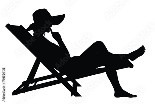 Silhouette shows a woman with a hat relaxing on a beach chair deep in thought
