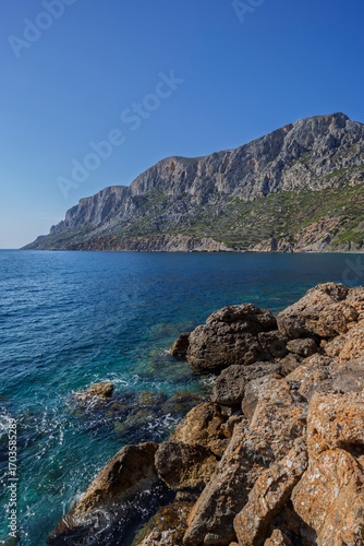 View of rocky coastline at the rugged Telendos island in Greece on a sunny day. Copy space.