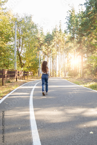 Wallpaper Mural Rear view of a little child girl walking alone in green park. Torontodigital.ca