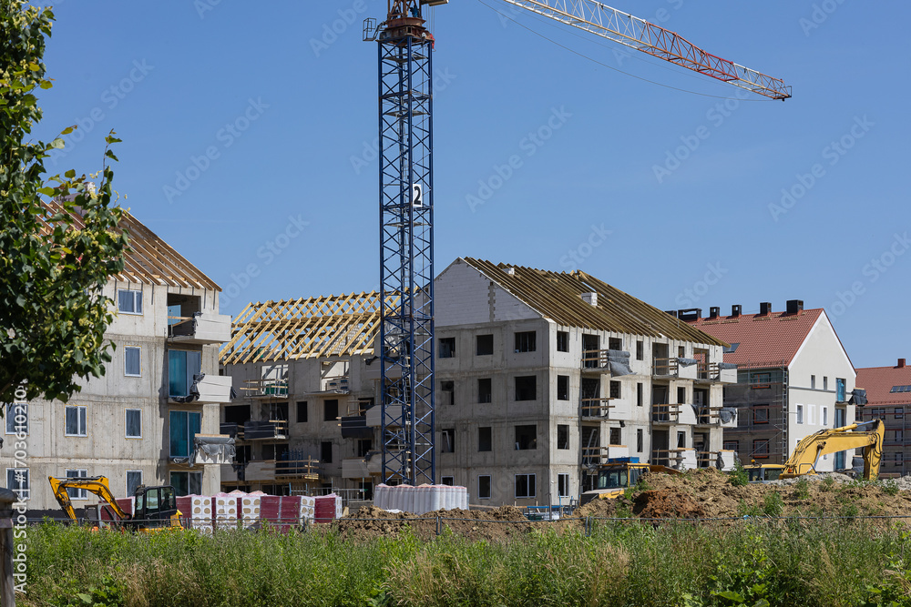 Fototapeta premium Modern low rise apartment buildings under construction in European neighborhood. Real estate investment, capital protection and financial growth through property ownership