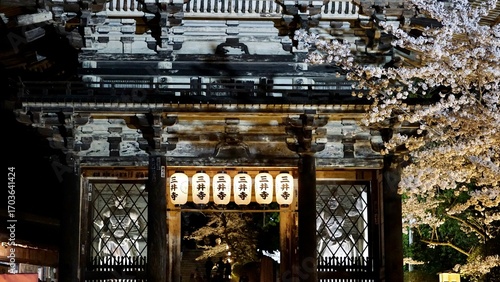 Night view of a Japanese temple gate with lit lanterns
