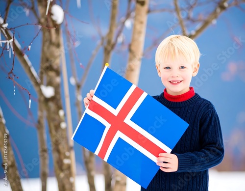 A young boy holding an Icelandic flag outdoors in winter