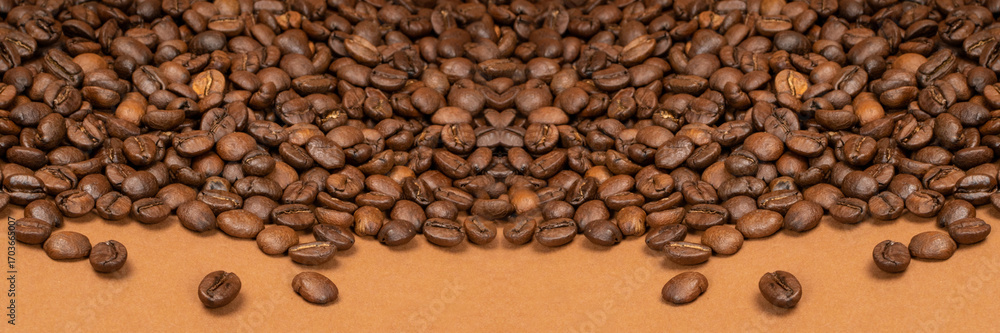 Naklejka premium Dark brown whole coffee beans on wood background with copyspace