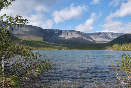 Panorama of a mountain lake on a bright sunny autumn day. Tourist place for recreation.