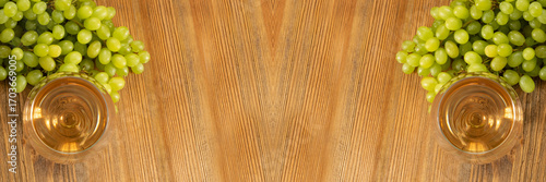 Fototapeta White Wine Glass on Ripe Green Grapes Background in Sunny Day