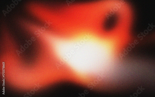 Abstract blurry orange and red light glowing in the dark grainy textured grunge background