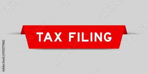 Red color inserted label with word tax filing on gray background