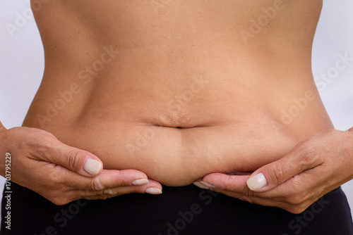 Bild auf Leinwand Close-up of womans abdomen, palms resting on lower belly