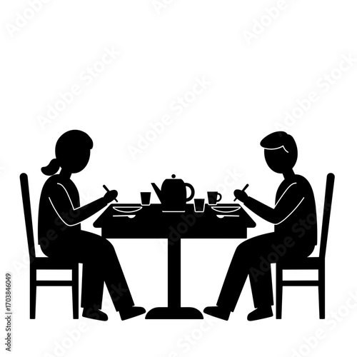 Silhouettes of two people sitting at a dinner table during Thanksgiving  