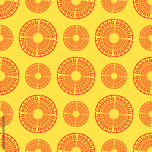 A seamless pattern of scattered red-orange medallions featuring a traditional Chinese key meander motif on a yellow background, evoking themes of wealth and good fortune.