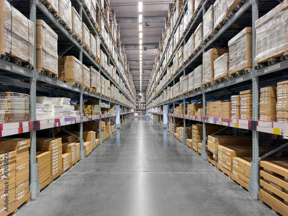 Large storage warehouse There is a walkway in the middle between the boxes shelves.