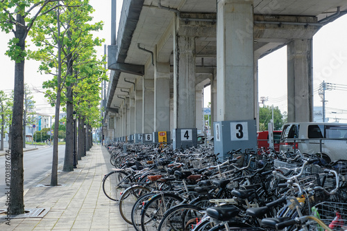 A busy urban bicycle parking area showcases eco-friendly transportation around a station in a Japanese city.