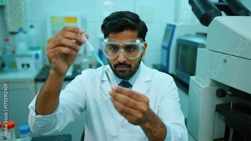 Indian male lab worker conducting chemical sample analysis