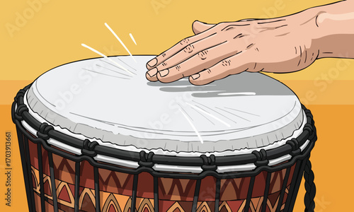 A hand striking a djembe drum with a white head and patterned body against a yellow background wall
