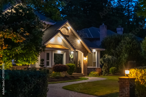 Two story stucco luxury house with big tree and nice landscape at night at Summer in Vancouver, Canada, North America. July 2025.