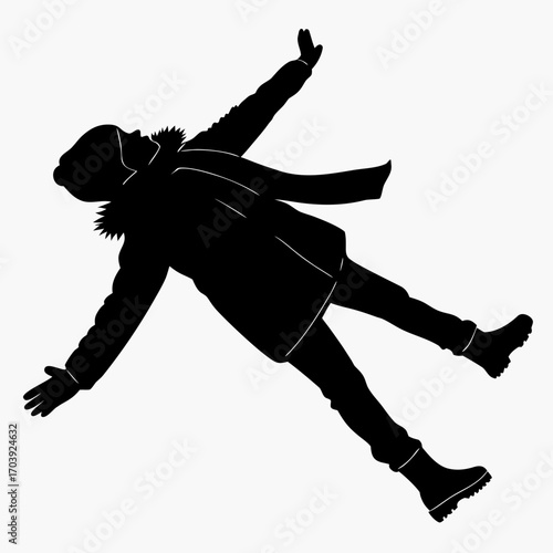Silhouette of a person in winter clothing lying down with arms outstretched in the snow creating a snow angel pose