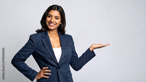 Smiling Businesswoman Presenting to the Side with Open Palm, Ready to Offer.