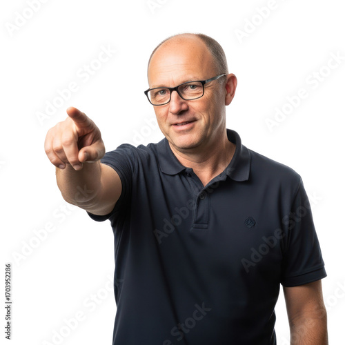 A man in a dark blue polo shirt pointing towards the camera with a neutral expression.
