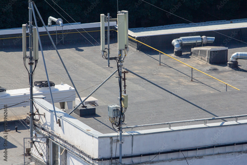 Fototapeta premium A close-up view of a mobile communication antenna installation on a flat roof, ideal for illustrating modern telecommunications technology, network infrastructure, or urban digital connectivity concep