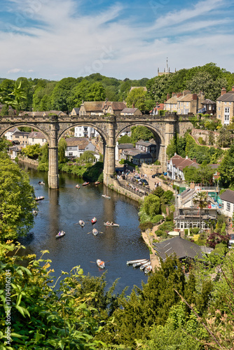 Εκτύπωση καμβά River Scene with Stone Bridge, Boats, and Buildings  in Knaresborough, UK