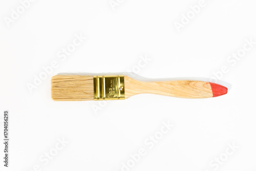 Single wooden-handled paintbrush with red tip and metal ferrule isolated - on white background. Brush size is 25 mm.