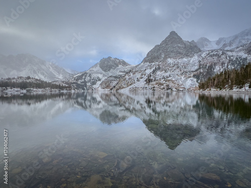 Page Peaks West and Epidote Peak Mountain Reflections in East Lake during a snow storm in the Sierra Nevada Mountains, California, USA