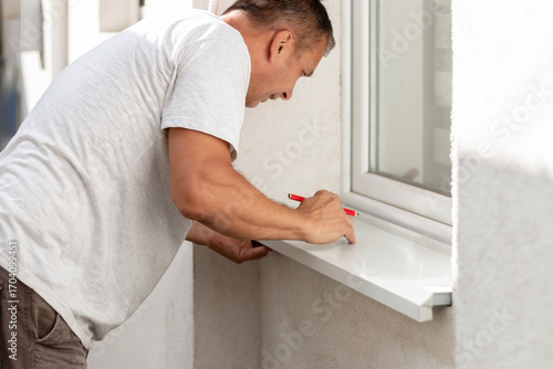 Foto The craftsman installing metal sill on external PVC window frame