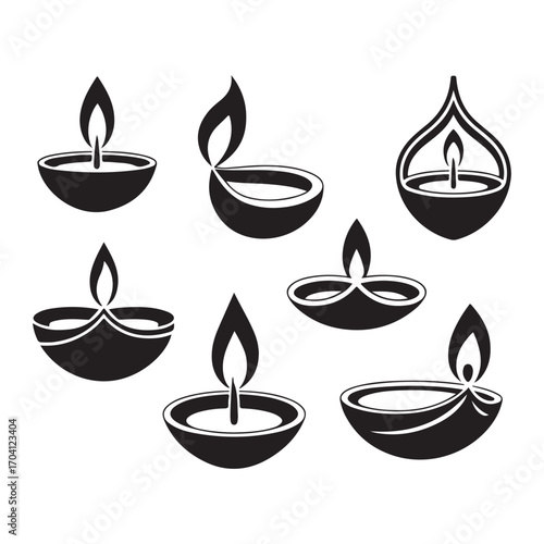 Collection of six black oil lamps with flames diya