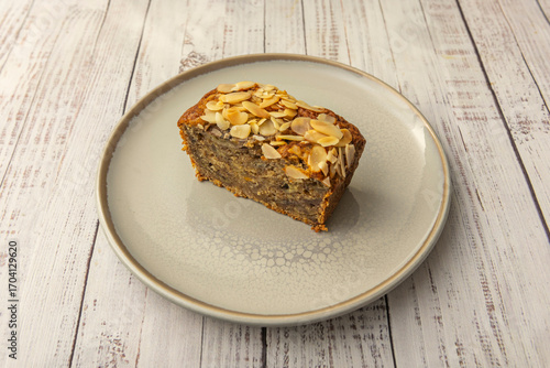Carrot sponge cake with walnut pieces and raisins, sprinkled with cinnamon and topped with a smooth cream cheese frosting and rustic decoration