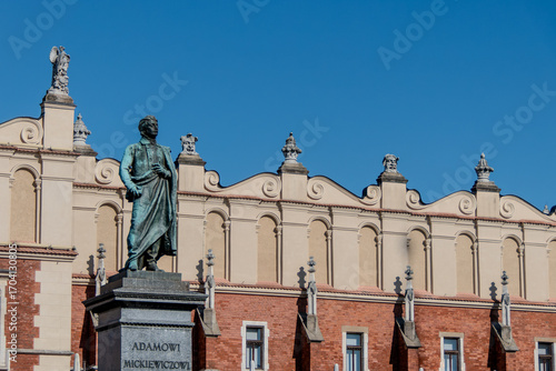 Krakow, Poland, August 5, 2025. Statue of the Romantic poet Adam Mickiewicz and the Cloth Hall