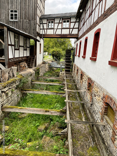 Detailansicht einer historischen Mühle mit Zulauf und Mühlrad
