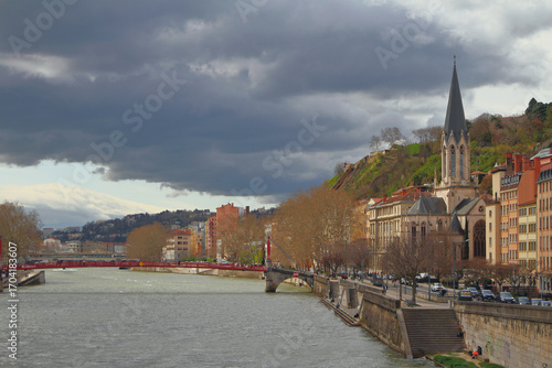 River, pedestrian bridge, embankment and church. Lyon, France
