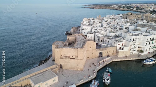 Aerial drone flight above Monopoli harbour, fortress and old city. Footage taken on June 22, 2025, in Monopoli, Apulia, Italy.

