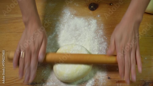 Rolling out the dough with a rolling pin for further preparation of dumplings