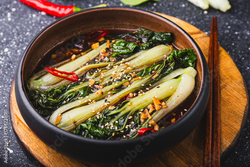 fried pak choi cabbage with garlic and soy sauce, Pak Choi or Bok Choy on grey background