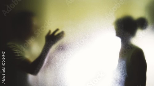Couple arguing behind the frosted glass