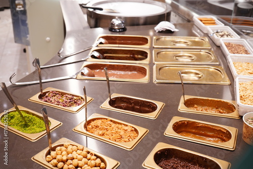 Colorful Ice Cream topping station with various sweets and sprinkles at a dessert shop - アイスクリーム屋のトッピングコーナー 選べるデコレーション スイーツショップの風景