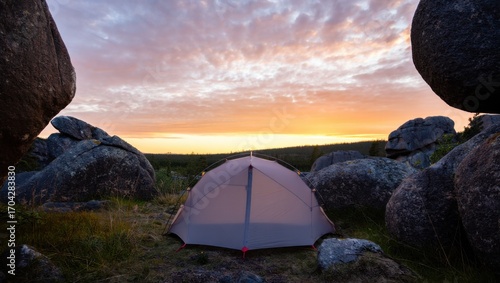 Serene Camping Experience in Nature: A Tent Surrounded by Massive Rocks Under a Beautiful Sunrise Sky