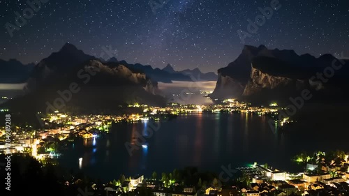 Nighttime lake view of city with mountains