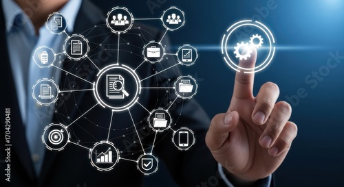 Businessman interacting with a digital network of business and finance icons on a dark background
