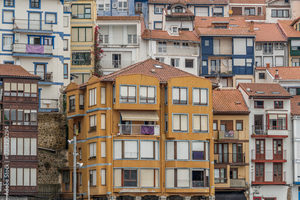 Fototapeta premium Colorful Basque Coastal Buildings With Traditional Bay Windows And Terracotta Roofs In Historic Fishing Village. Northern Architecture Wooden Shutters