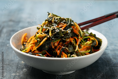 Wakame Seaweed Salad with carrot and zucchini in a bowl. Healthy food.