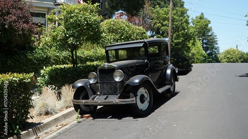 Obraz na płótnie Vintage black classic car from early 20th century parked along suburban street