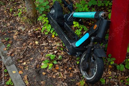 Wallpaper Mural A damaged public electric scooter lies on the side of the road. The photo was taken on a cloudy day with natural lighting. Torontodigital.ca