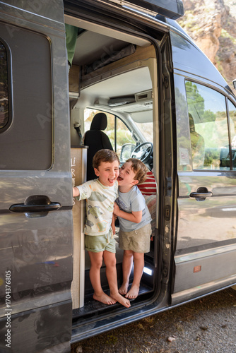 Two brothers having fun on camper van summer vacation